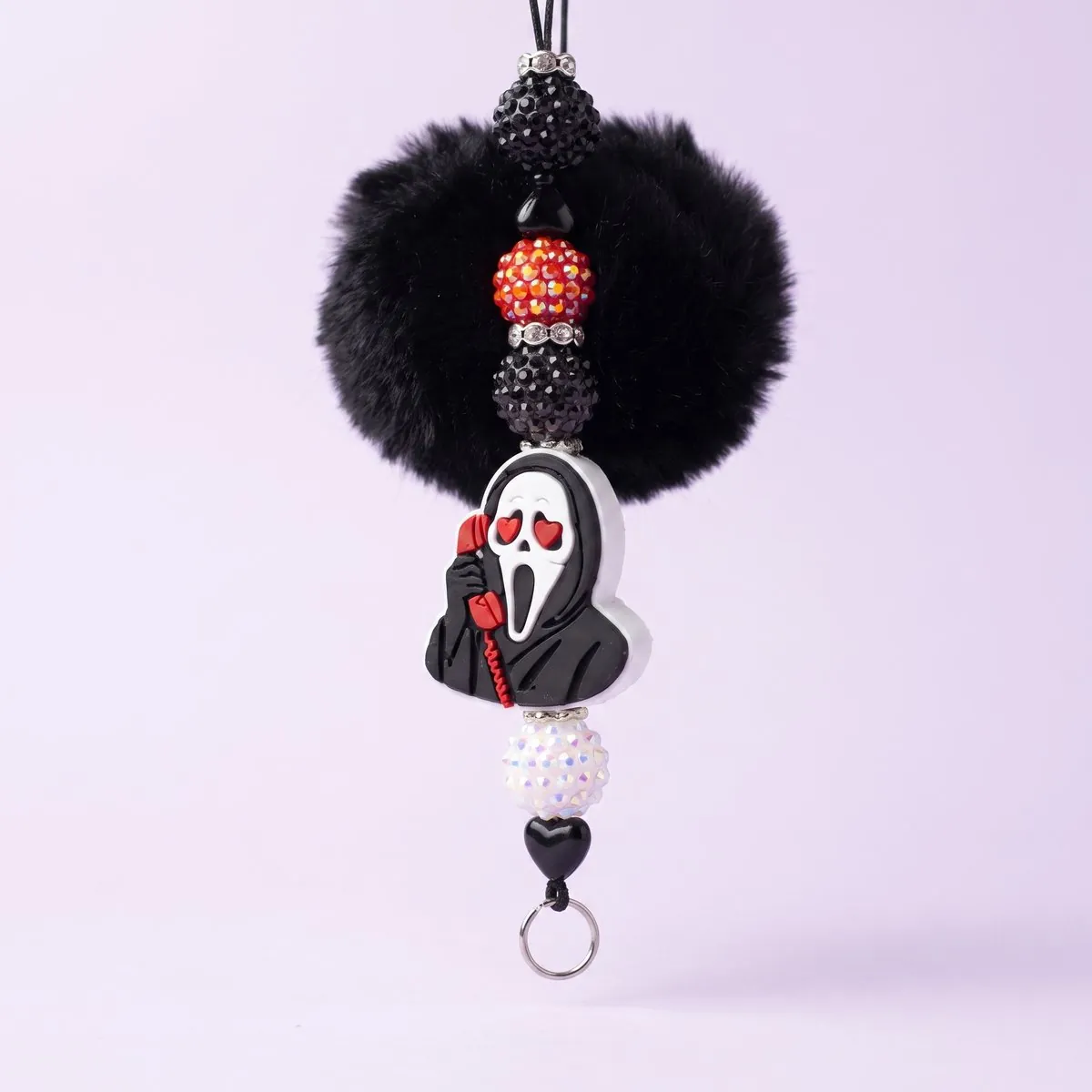 Ghost Hearts Charm hanging from its black cord — a black faux-fur pom above a hooded ghost charm with heart eyes holding a red telephone, strung with black, red and white rhinestone beads, black heart beads and a silver key ring