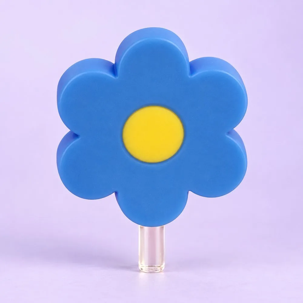 Blue Daisy Topper on a clear straw, pale lavender backdrop — shaped like a blue daisy with a yellow center