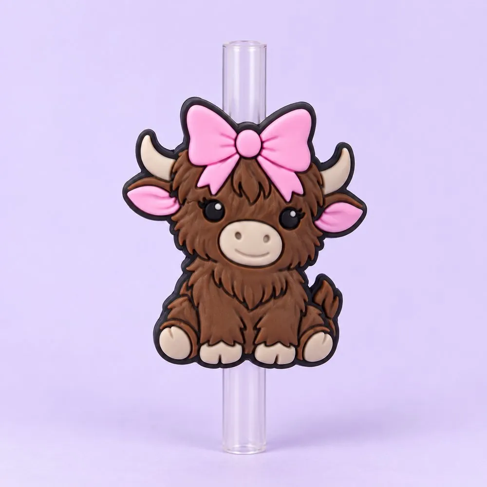 Highland Cow Topper on a clear straw, pale lavender backdrop — shaped like a brown fluffy highland cow with a pink bow