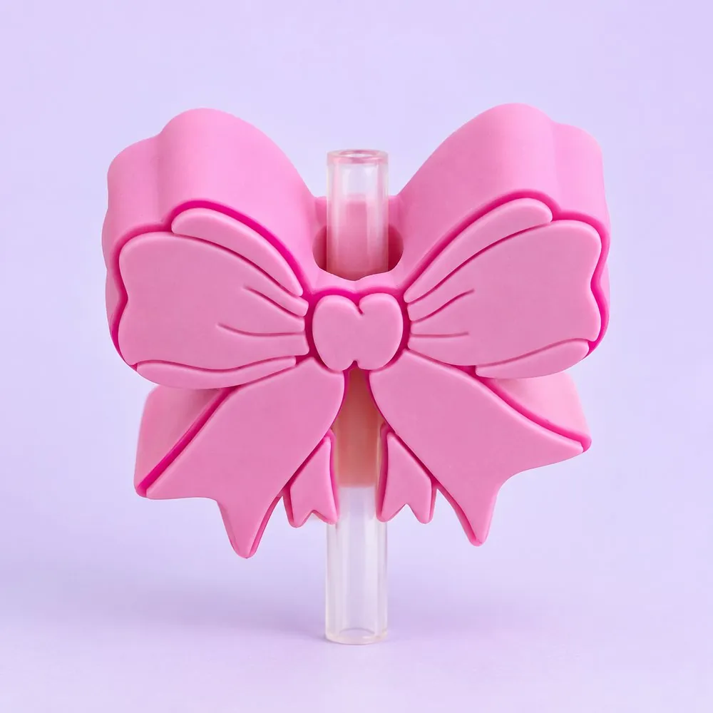 Pink Bow Topper on a clear straw, pale lavender backdrop — shaped like a pink bow with darker pink outlines