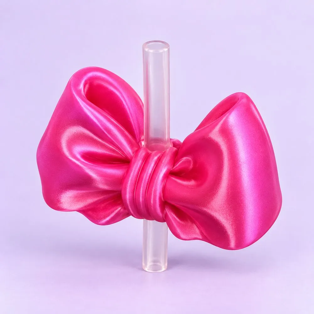 Satin Bow Topper on a clear straw, pale lavender backdrop — shaped like a hot pink satin ribbon bow
