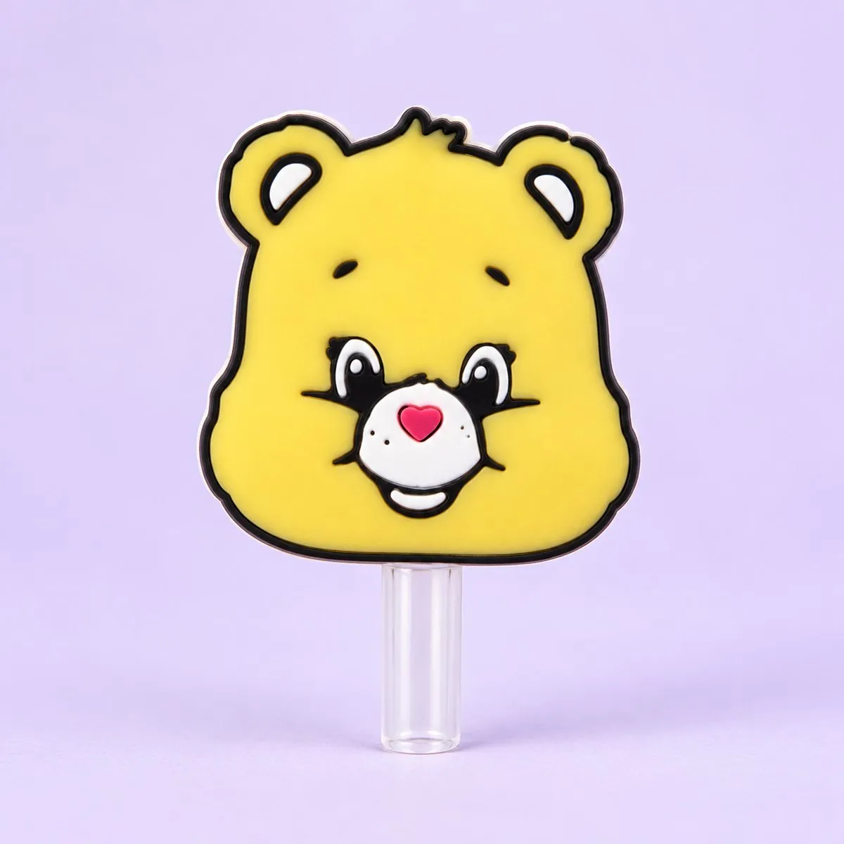 Sunny Bear Straw Topper on a pale lavender backdrop — a flat yellow cartoon bear head with a pink nose, white muzzle and a small sun on its forehead, a cut-out straw charm with a white outline, sitting on a clear straw
