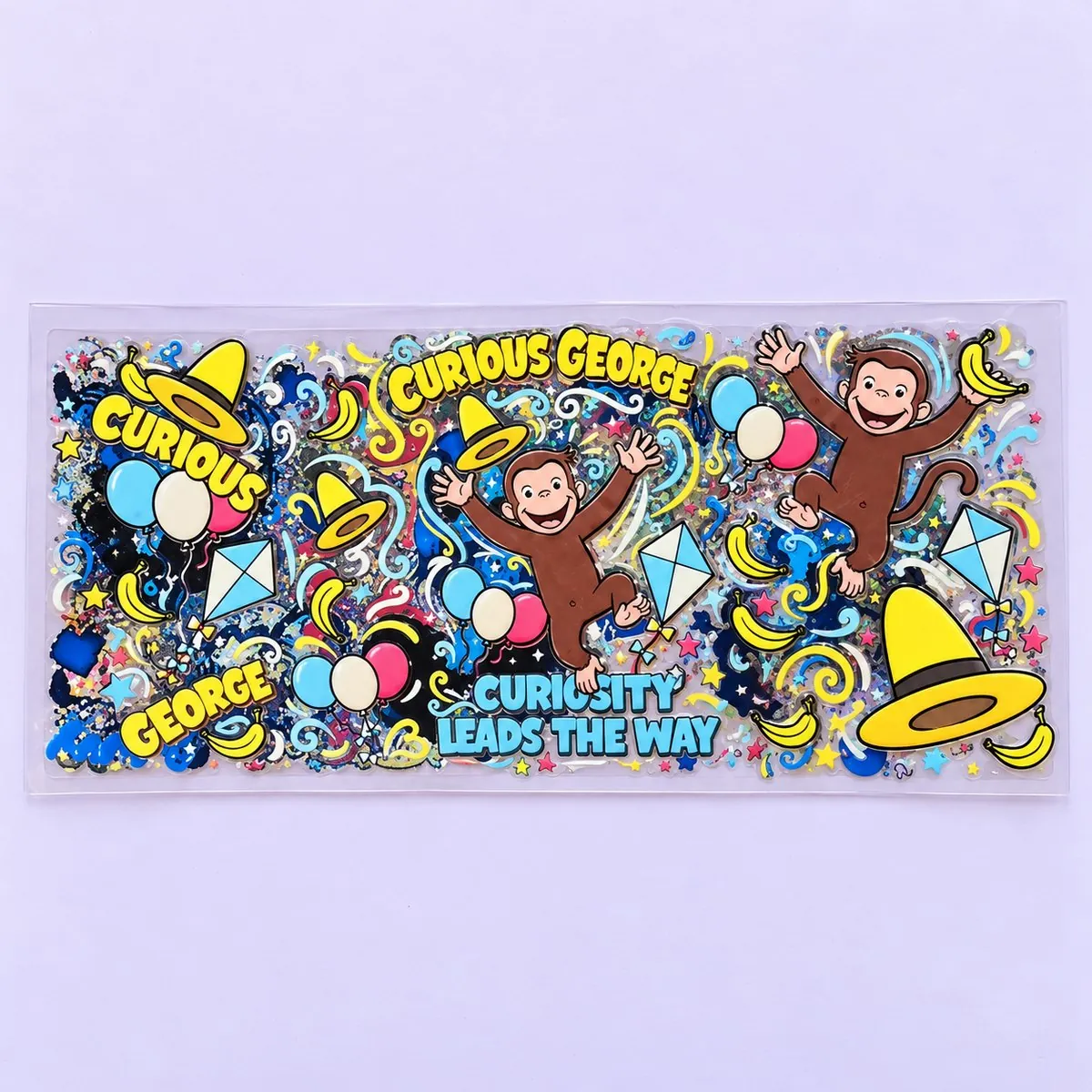 Curious Little Monkey cup wrap laid flat — a brown monkey with a yellow hat, balloons and kites, lettered 'Curious George' and 'Curiosity leads the way'